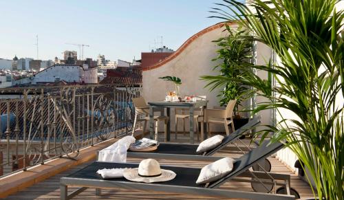 a balcony with a table and chairs on a roof at Eric Vökel Boutique Apartments - Madrid Suites in Madrid