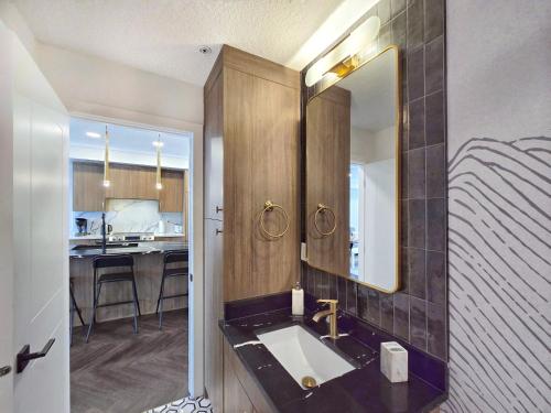a bathroom with a sink and a mirror at Family Stylish 2BR Condo with City View, DT, Balcony, Free Parking & In-Suite Laundry! in Calgary