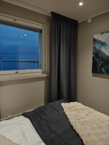 a bedroom with a bed and a large window at ArticLoft Kemi in Kemi
