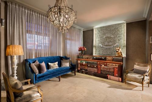 a living room with a blue couch and a chandelier at Grand Daddy Boutique Hotel in Cape Town