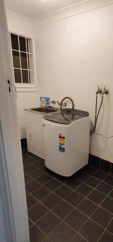 una cucina con vasca in un angolo della camera di KarenResidence a Cabramatta