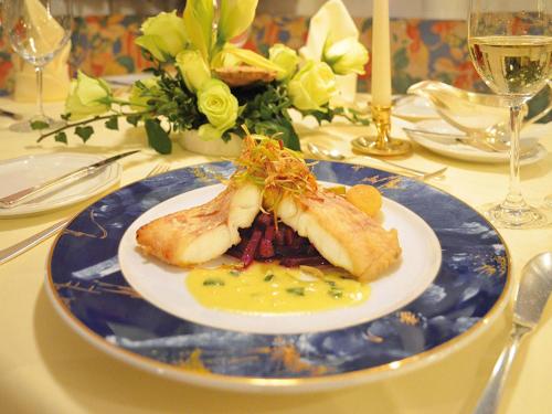 a blue and white plate with food on a table at Akzent Hotel Haus Surendorff in Bramsche