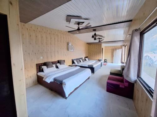 a large bedroom with two beds and a window at Valley King Resort in Rishīkesh
