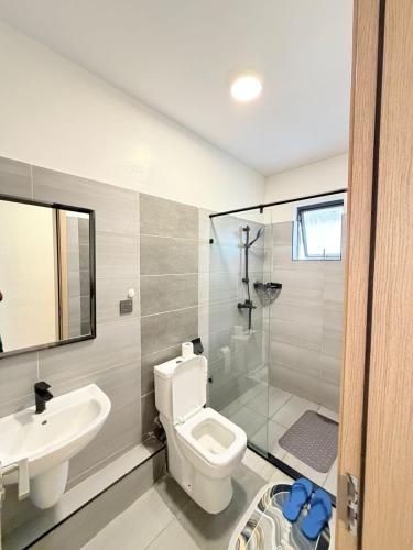 a bathroom with a toilet and a sink and a shower at Ww homes 2bedroom Apartment in Nairobi