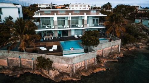Villa Mariposa Ocean Front Mansion with Infinity Pool في غانيكا: منظر جوي لمنزل به حوض سباحة