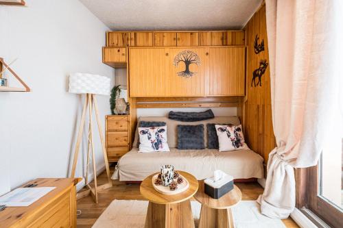 een kleine slaapkamer met een bed en een tafel bij Studio Champ Pérouze in La Toussuire