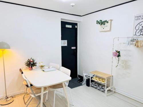 a room with a white table and a black door at Won-Stay in Samgong