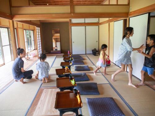 um grupo de crianças caminhando por uma sala com tapetes de ioga em SUNAORetreat奥白浜 em Minamiboso