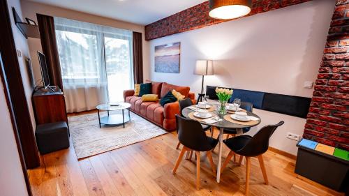 Zielony Zdrój, Sun & Snow في كرينيتسا زدروي: غرفة معيشة بها طاولة وأريكة