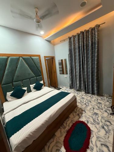 a bedroom with a large bed with blue pillows at Sodhi Residency in Amritsar