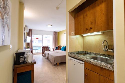 a kitchen with a sink and a room with a bed at Apartamentos La Jabega in Fuengirola