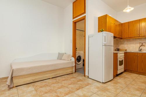 a small kitchen with a white refrigerator in a room at Panoramio Paleochora Apartments in Palaiochóra
