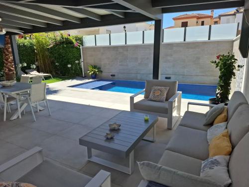 een woonkamer met een zwembad en een patio bij Villa Corni in Granada