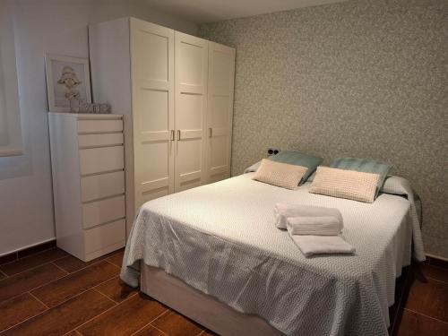 een slaapkamer met een wit bed met handdoeken erop bij Villa Corni in Granada