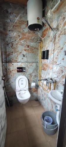 a stone bathroom with a toilet and a sink at Cosmic Buddha Bnb in Gangtok