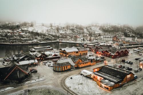 a town covered in snow next to a body of water at Flåmsbrygga Apartments in Flåm