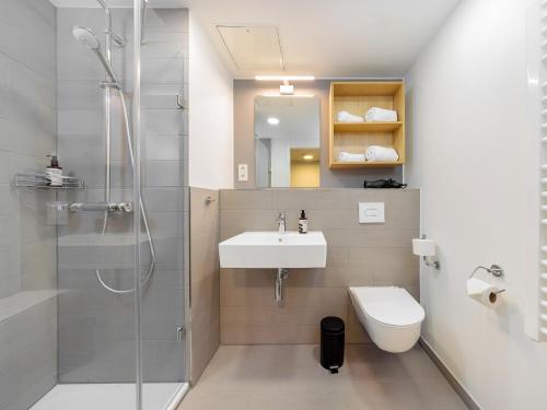 a bathroom with a shower and a sink and a toilet at smartments Hamburg Hamm in Hamburg