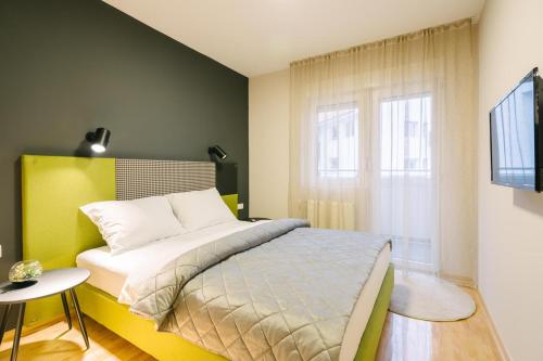 a bedroom with a bed and a window at NAR Royalton Apartment #60 in Niš