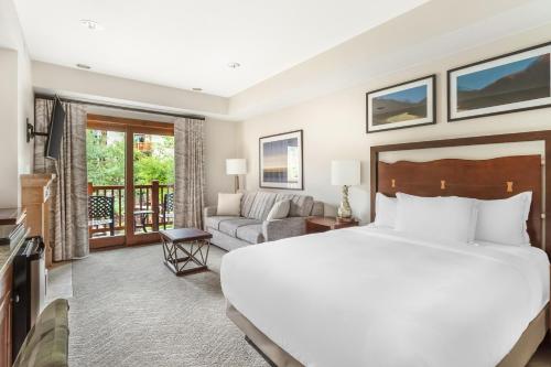 a bedroom with a large bed and a living room at Hilton Grand Vacations Club Sunrise Lodge Park City in Park City