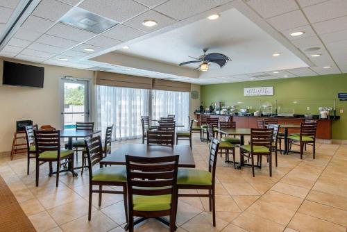 a dining room with tables and chairs and a bar at Sleep Inn & Suites Port Charlotte-Punta Gorda in Port Charlotte