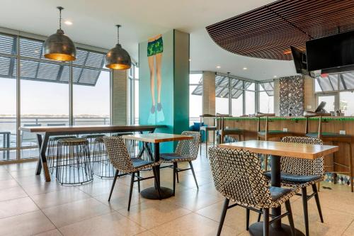 Un restaurante con mesas, sillas y ventanas. en Cambria Hotel Ocean City - Bayfront, en Ocean City