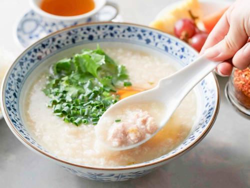 東京にあるコンフォートイン東京六本木のスープボウルにスプーンを持っている人