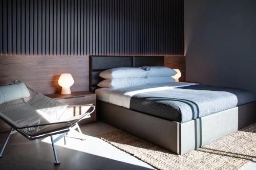 una camera da letto con un letto e una sedia di Black C House Modern w pool spa a Yucca Valley