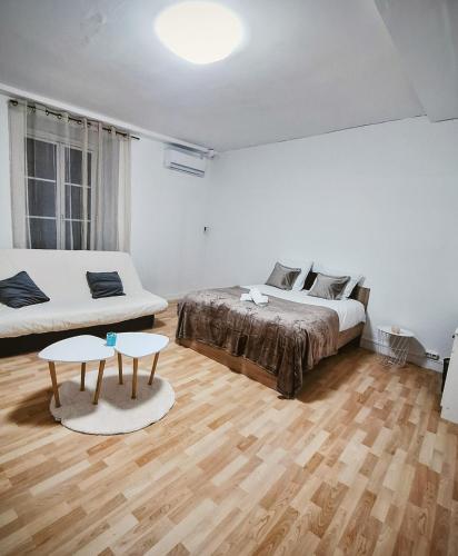 a bedroom with a bed and a couch and a table at La maison du château in Saint-Victurnien
