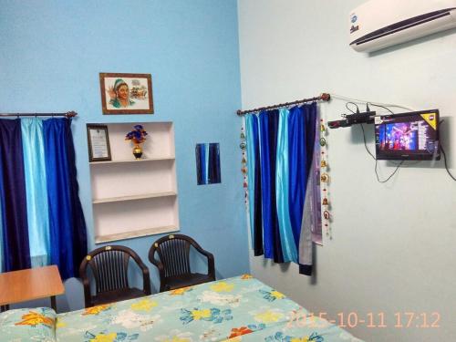 a room with a bed and a table and a television at Shri Krishna Residency in Sawāi Mādhopur