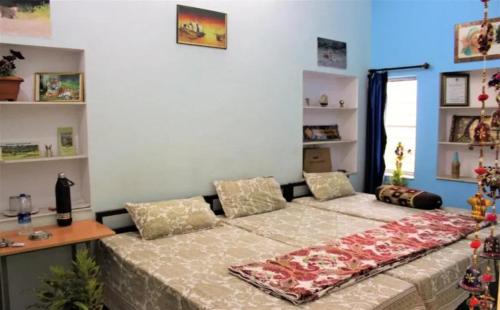 a bedroom with a bed with a table and shelves at Shri Krishna Residency in Sawāi Mādhopur
