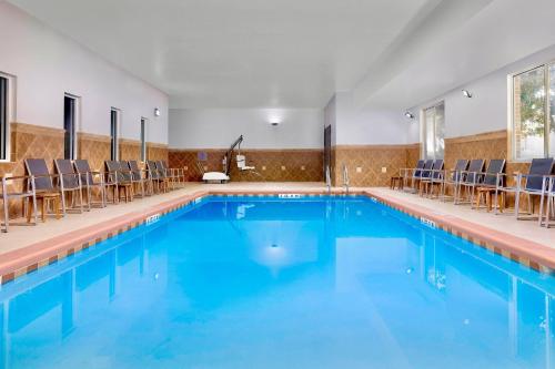 a swimming pool with chairs in a building at Country Inn & Suites by Radisson, Gainesville, FL in Gainesville