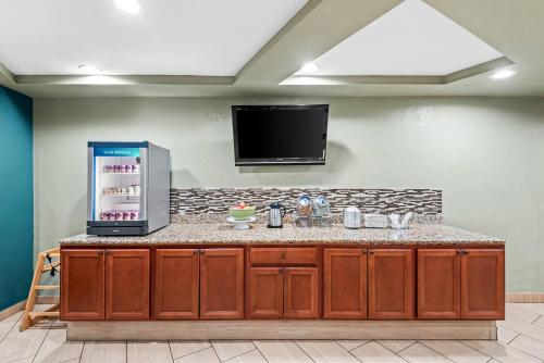 a kitchen with a refrigerator and a tv on the wall at Quality Inn West Des Moines - Clive in West Des Moines
