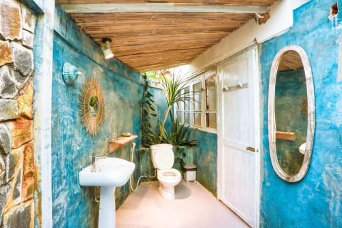 Lara Homestay في Ấp Gò Dinh: حمام ازرق مع مرحاض ومغسلة