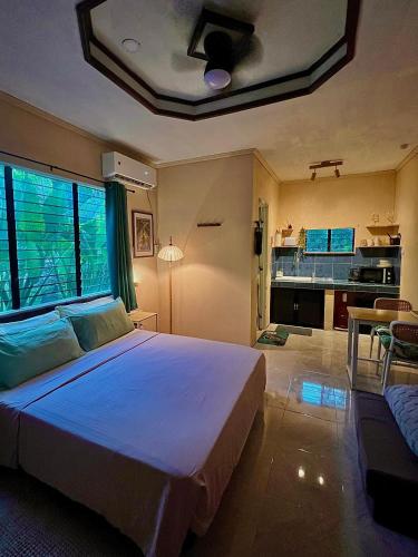 een slaapkamer met een groot bed en een woonkamer bij Palm Haven w Starlink in Siquijor