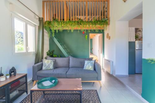 a living room with a couch and a table at Jungle Room avec Jacuzzi privé in Bastelicaccia