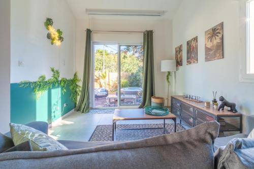 a living room with a couch and a table at Jungle Room avec Jacuzzi privé in Bastelicaccia