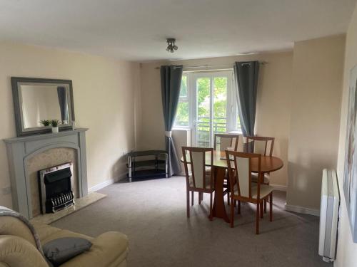 a living room with a table and chairs and a fireplace at Friars terrace in Stafford