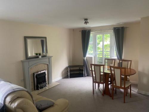 a living room with a table and chairs and a fireplace at Friars terrace in Stafford