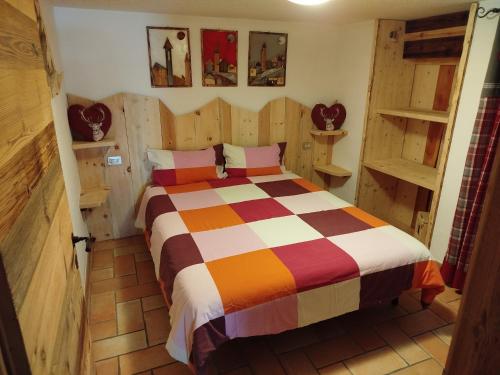 Un dormitorio con una cama en una habitación con paredes de madera. en Botton d'oro, en Campitello di Fassa