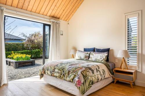 Ένα ή περισσότερα κρεβάτια σε δωμάτιο στο Roys Peak House, Architectural Gem in Wanaka