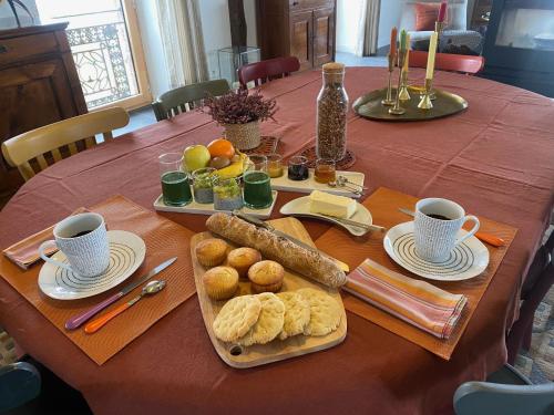 una mesa con un plato de pan y dos tazas de café en La Béraine "rien que pour vous", en Vergues