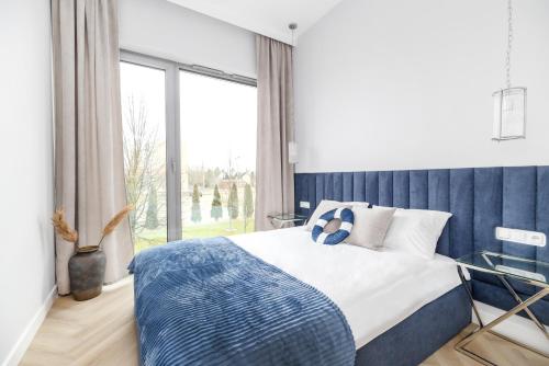 ein Schlafzimmer mit einem Bett und einem großen Fenster in der Unterkunft Apartament Heaven Hampton in Olsztyn