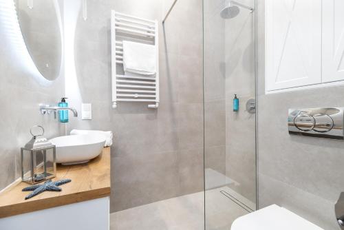 ein Badezimmer mit Dusche, Waschbecken und Toilette in der Unterkunft Apartament Heaven Hampton in Olsztyn