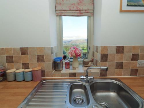 a kitchen sink and a window with a view at Hawkrigg Cottage in Barbon