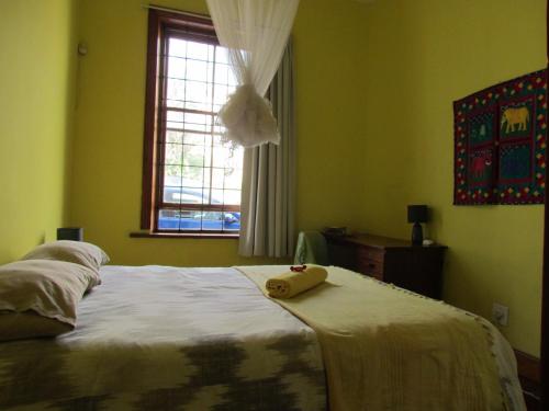 een slaapkamer met een bed met een knuffeldier erop bij Victorian Woodstock in Kaapstad
