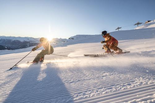 two people skiing down a snow covered slope at Apart Simple Living in Zell am Ziller