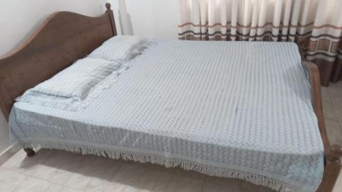 a bed with a wooden frame in a room at New Moon in Pannipitiya