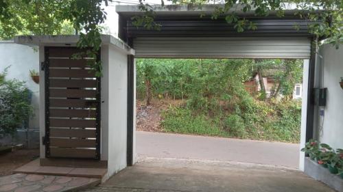 an open garage door leading to a driveway at New Moon in Pannipitiya