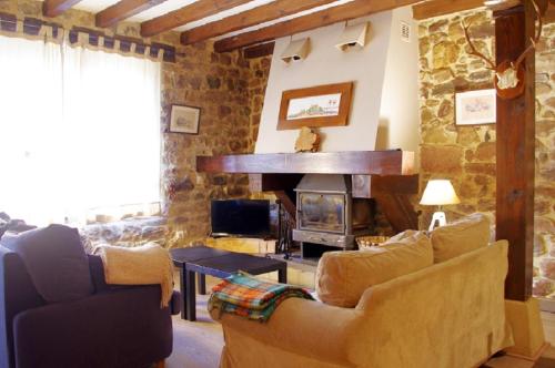 ein Wohnzimmer mit Sofa und Kamin in der Unterkunft El Rincón del Besaya in Villasuso de Cieza
