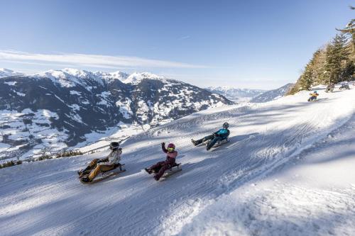 a group of people riding down a snow covered mountain at Apart Simple Living in Zell am Ziller